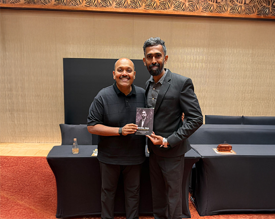 Two founders standing together at an event, with Selvakumar founder of 123 Total Web Solutions presenting his book `Digital DNA` with Suren founder of success Gyan.