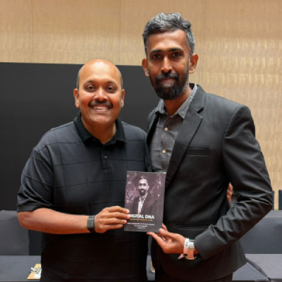 Two founders standing together at an event, with Selvakumar founder of 123 Total Web Solutions presenting his book `Digital DNA` with Suren founder of success Gyan.